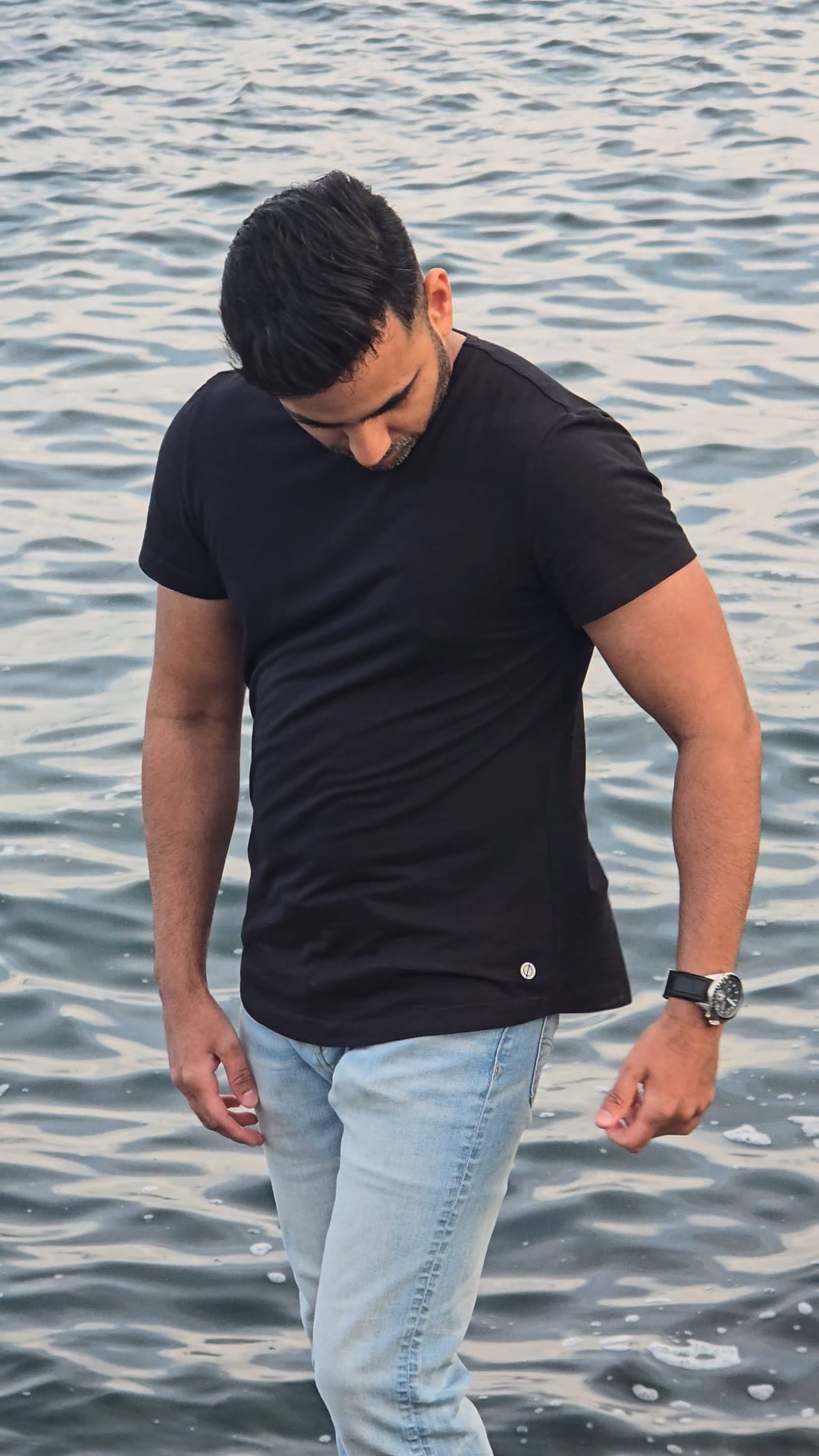 Man wearing Drøn black t-shirt side view— modern athletic fit, versatile for gym or everyday wear. Sustainable clothing for the man who wants everything.